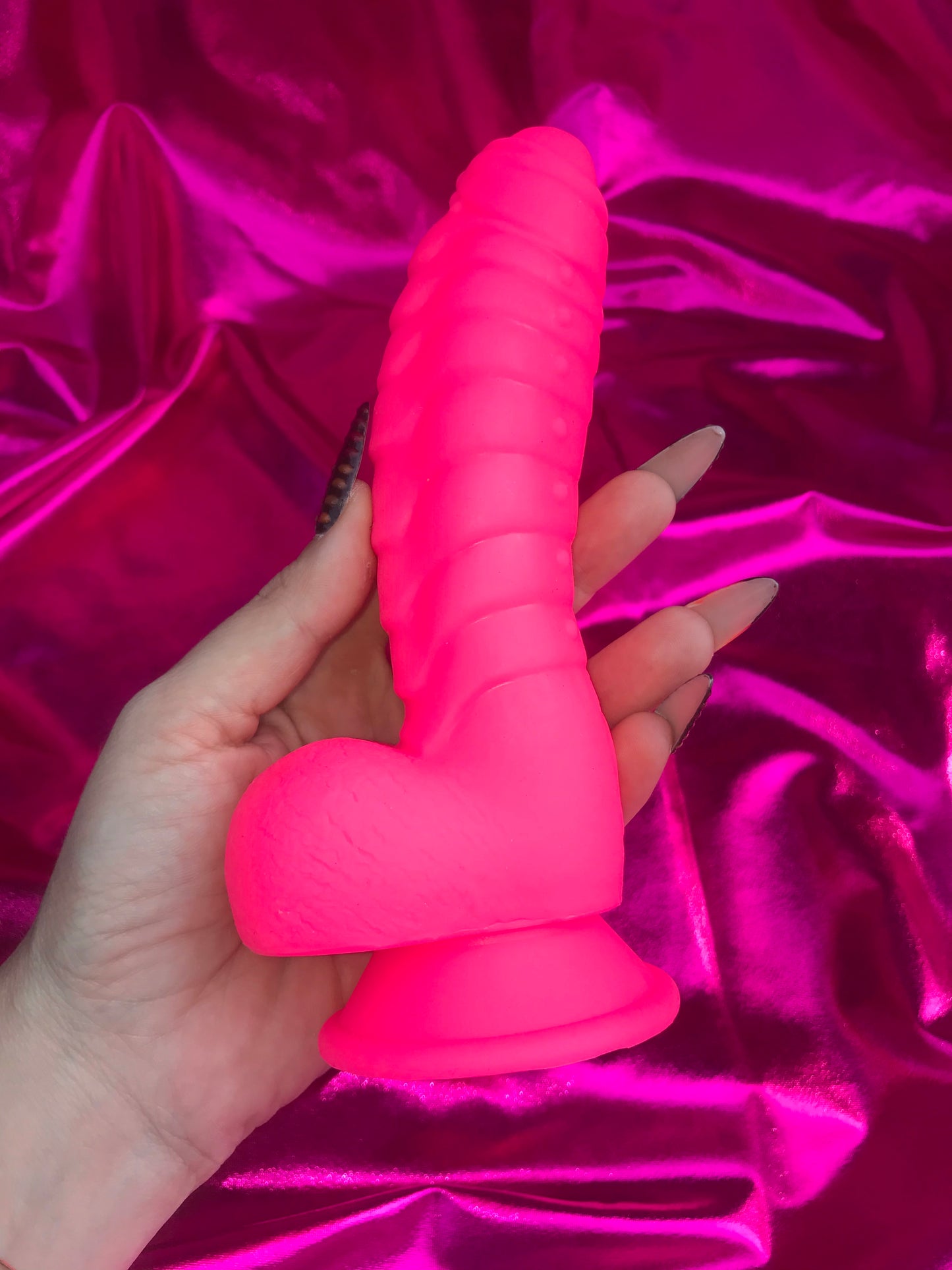 Neon pink silicone devil dildo with suction cup.