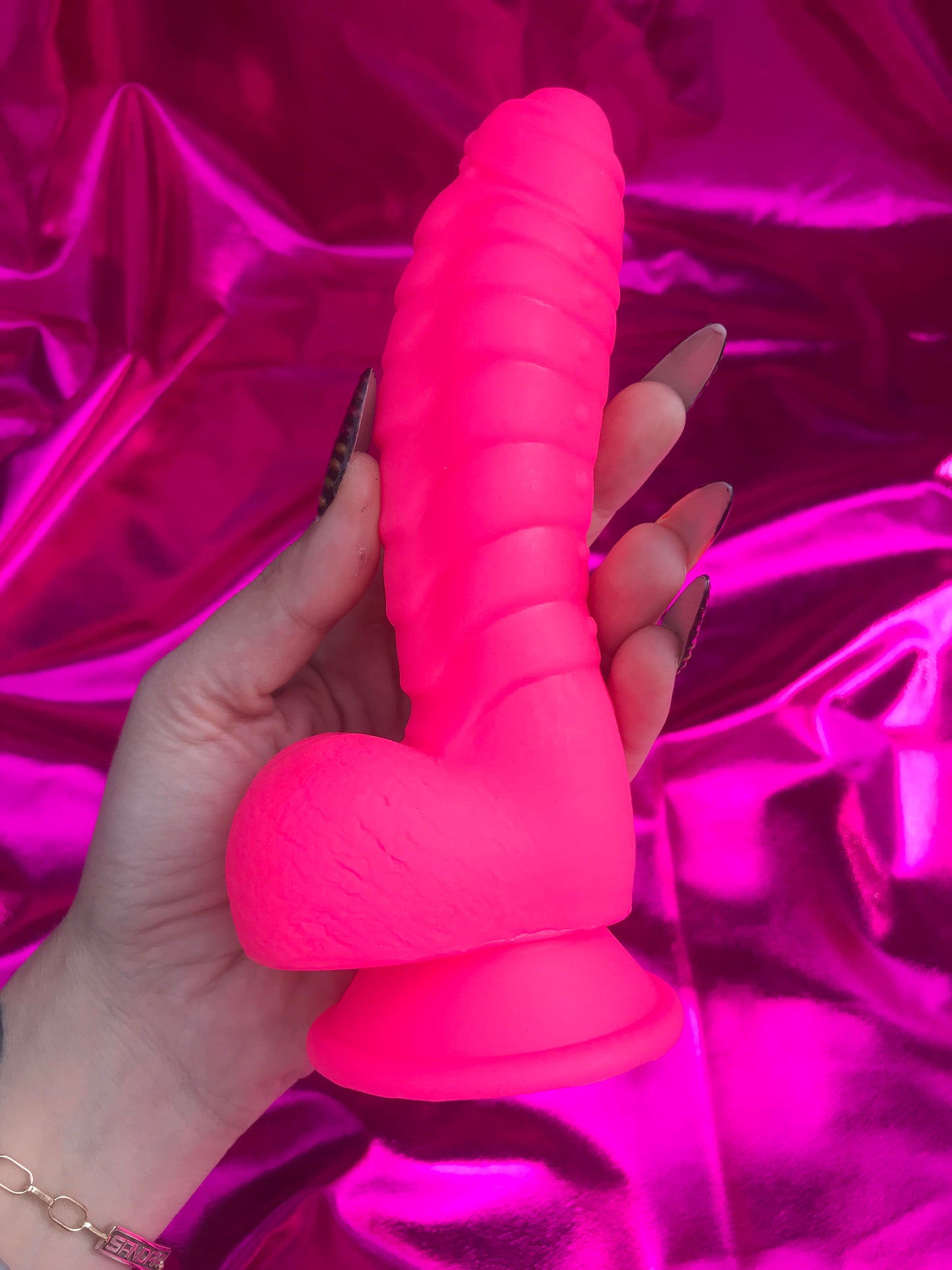 Neon pink silicone devil dildo with suction cup.