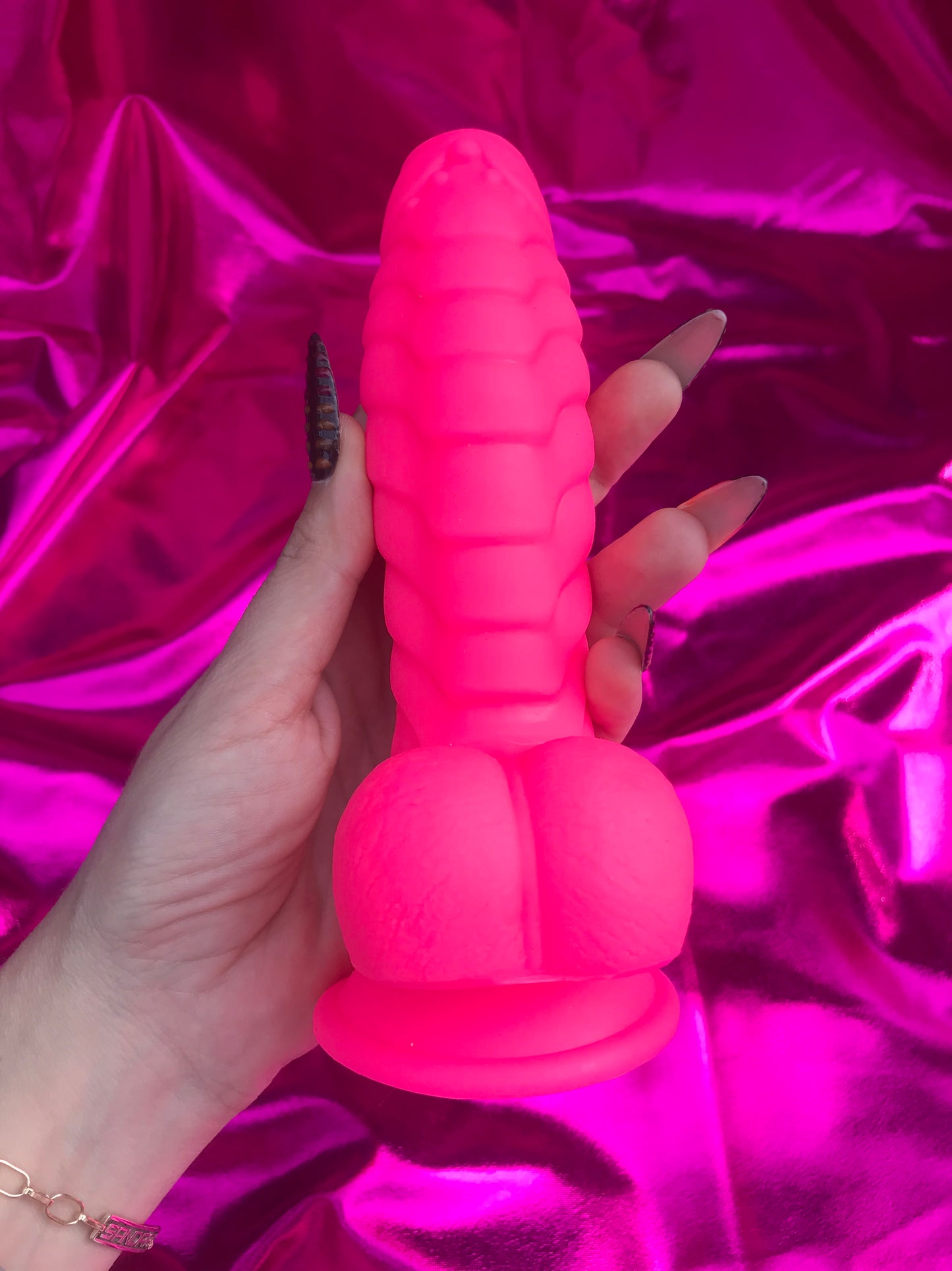 Neon pink silicone devil dildo with suction cup.