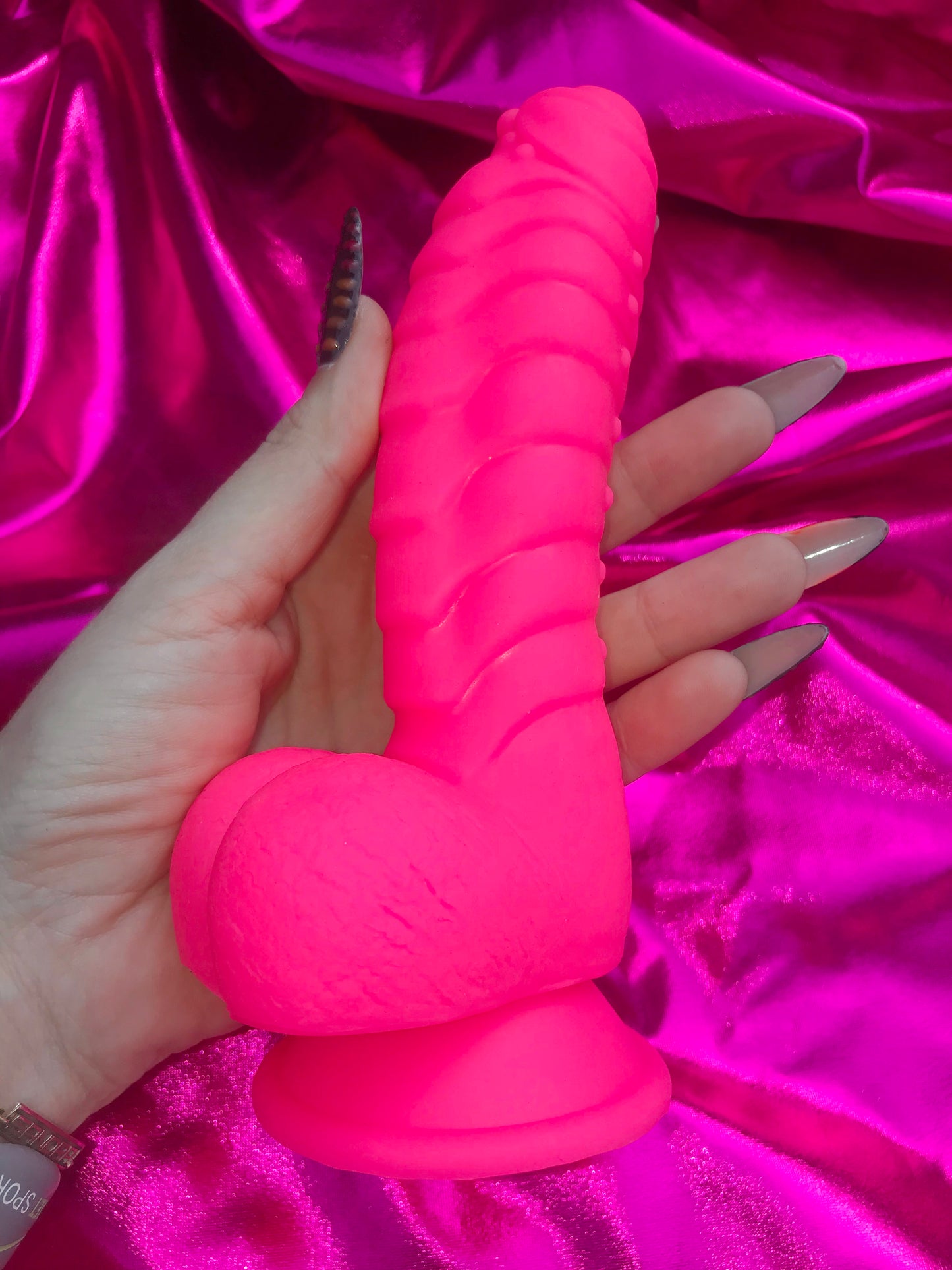 Neon pink silicone devil dildo with suction cup.