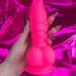 Neon pink silicone devil dildo with suction cup. 