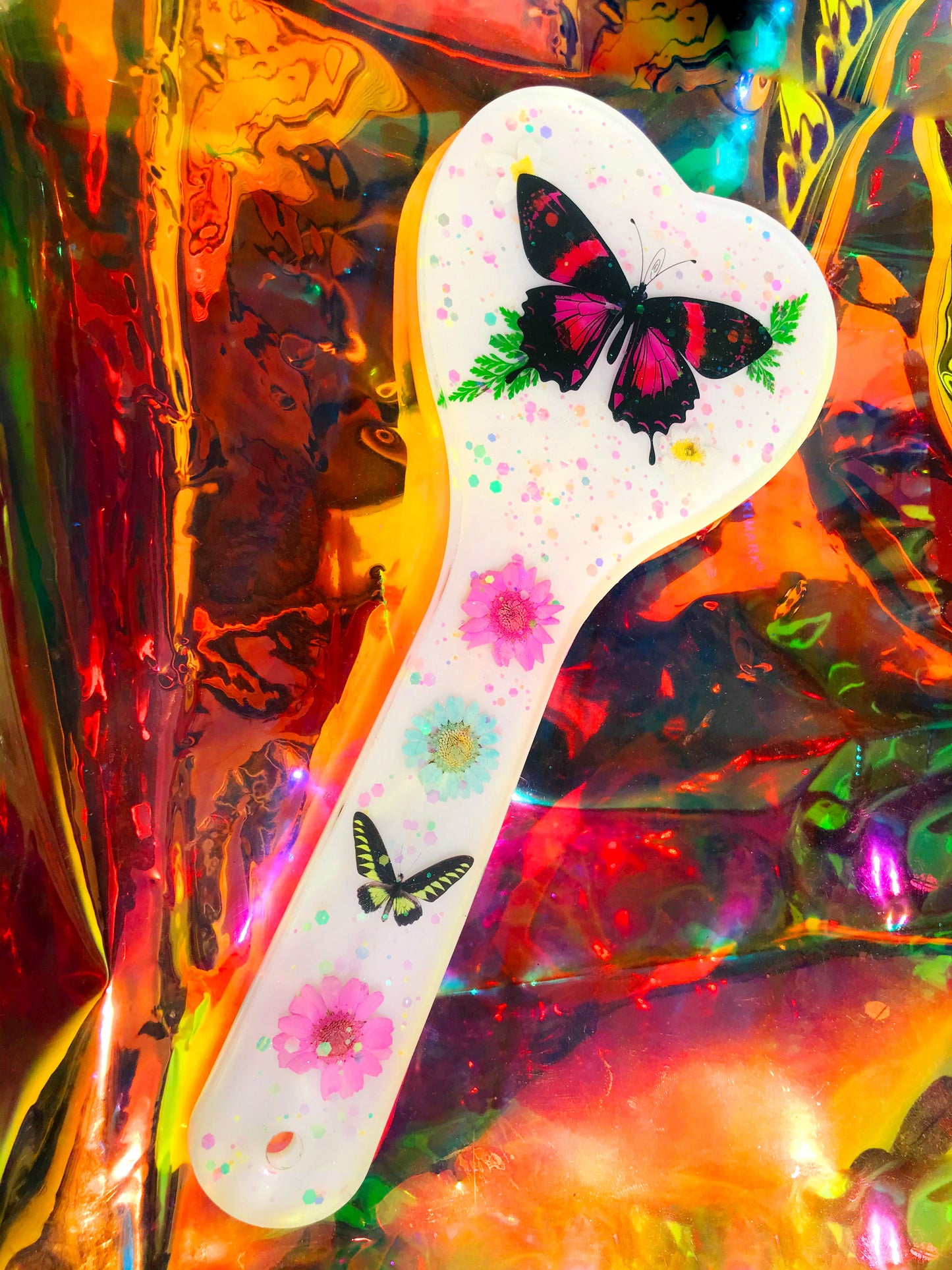 Heart shaped resin spanking paddle made of resin, flowers, butterflies and glitter