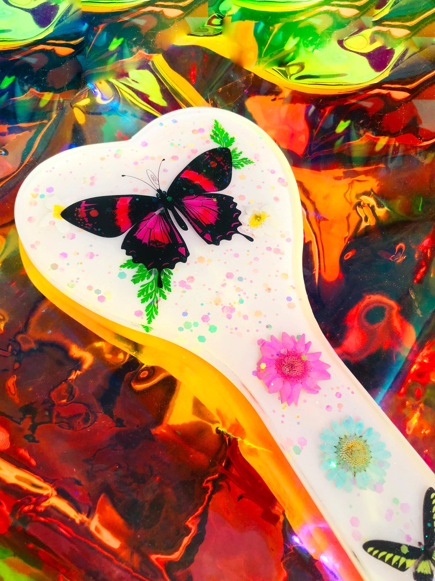 Heart shaped resin spanking paddle made of resin, flowers, butterflies and glitter