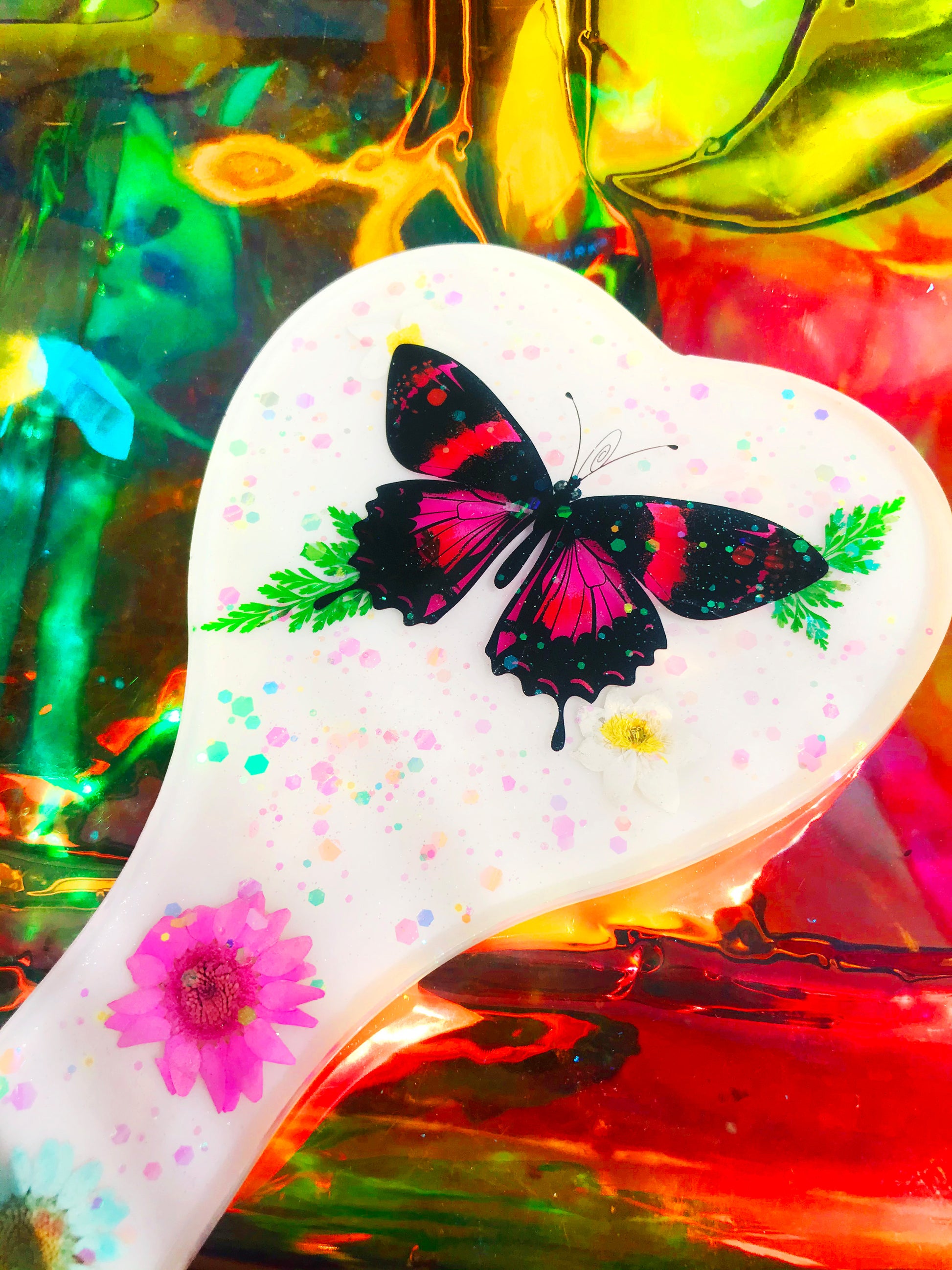 Heart shaped resin spanking paddle made of resin, flowers, butterflies and glitter