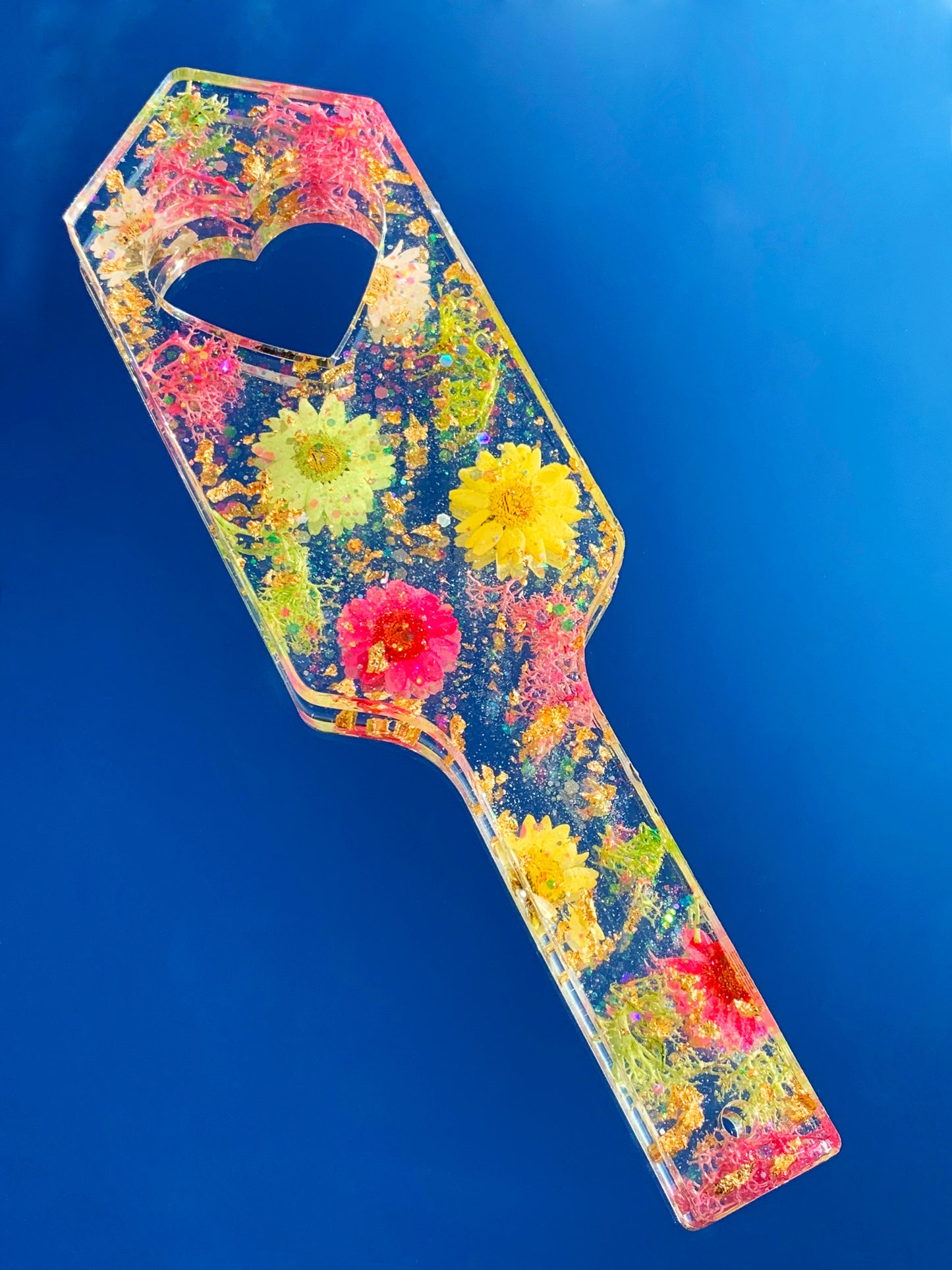 Resin spanking paddle with dried flowers, gold flakes and glitter holographic paper